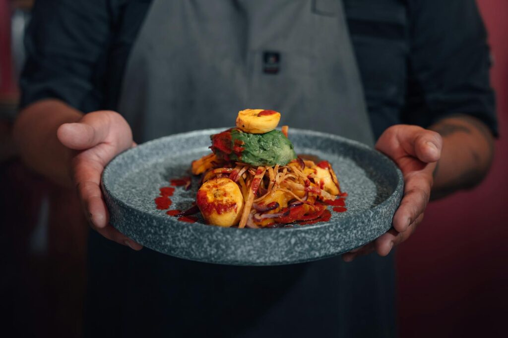 A chef holding a plate of food with natural male enhancement products